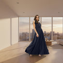 A woman modeling a sleeveless, floor-length navy blue maxi dress with a gathered waist and flowing skirt, shown against a plain white background.