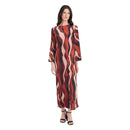 A woman modeling a long-sleeved maxi dress with an abstract wavy pattern in rust red, black, and beige, paired with black strappy heels, against a plain white background.