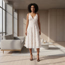 A woman modeling a sleeveless lace midi dress with a deep V-neckline and flared skirt, shown against a plain white studio background.