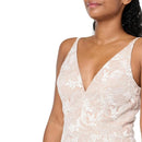 A close-up of a model wearing a white floral lace camisole top with a deep V-neckline against a plain white background.