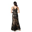A woman viewed from the back wearing a sleeveless black lace maxi dress with a sheer floral pattern and a V-neckline, set against a plain white background.